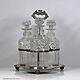 Early Victorian set of three cut glass cylinder decanters, silver plated stand