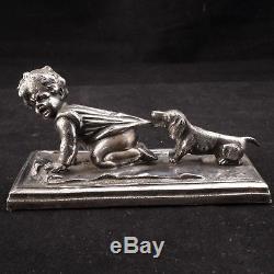 German silver plate paperweight of a child being pulled by a Dachshund Ca 1880